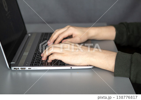 Person typing on a laptop at a desk for remote work and digital productivity Person typing on a laptop at a desk for remote work and digital productivity 138776817