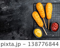 Crispy corndogs with ketchup and mustard on dark background, deep fried street food snack with copy space, top view 138776844