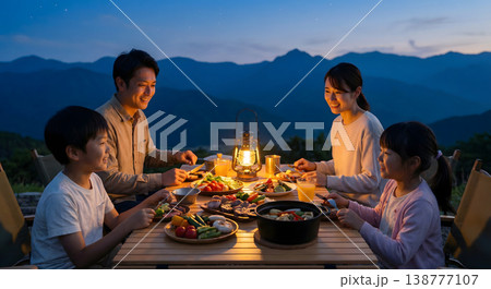 夕暮れの山でキャンプ飯を楽しむ4人家族 豪華なディナー 笑顔 138777107