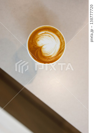 Cup of hot milk latte coffee with heart shape latte art on table. Cup of hot milk latte coffee with heart shape latte art on table. 138777720