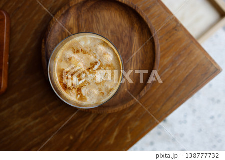Cup of chilled milk dirty coffee on table by the window. 138777732