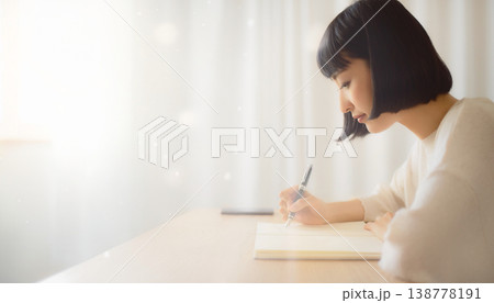 ノートに書きながら考える女性の横顔と集中する時間 138778191
