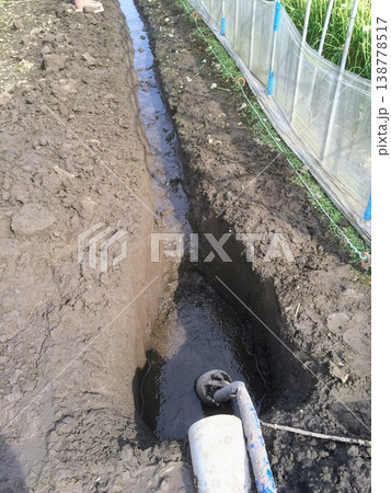 畑に湧き出した井戸水の排水作業 138778517