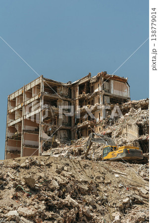 A destroyed apartment building ruins under active demolition 138779014