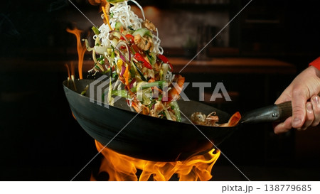 Freeze Motion of Flying Asian Meal with Vegetable and Prawns into Wok Pan Freeze Motion of Flying Asian Meal with Vegetable and Prawns into Wok Pan 138779685