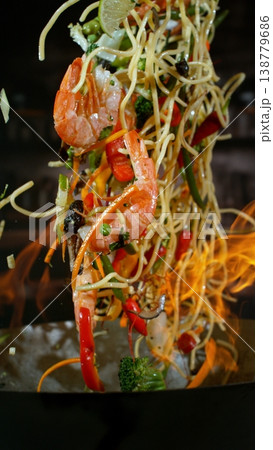 Freeze Motion of Flying Asian Meal with Vegetable and Prawns into Wok Pan 138779686