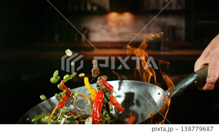 Freeze Motion of Flying Asian Meal with Vegetable and Meat into Wok Pan 138779687