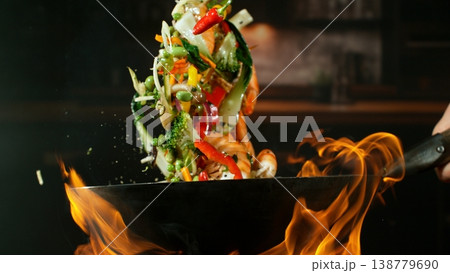 Freeze Motion of Flying Asian Meal with Vegetable and Prawns into Wok Pan Freeze Motion of Flying Asian Meal with Vegetable and Prawns into Wok Pan 138779690