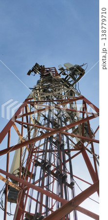 Telecommunication tower rising high with antennas and cables under clear blue sky Telecommunication tower rising high with antennas and cables under clear blue sky 138779710