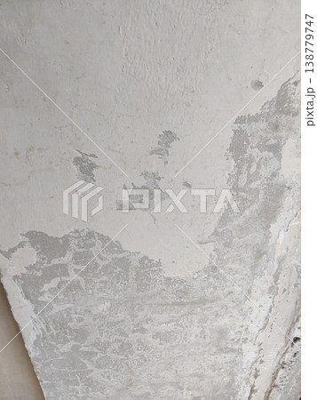 Wall surface with peeling paint showing moisture damage and cracked plaster layers on building interior Wall surface with peeling paint showing moisture damage and cracked plaster layers on building interior 138779747