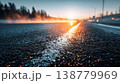 Wet asphalt road at sunrise with glowing light reflection and motion blur 138779969