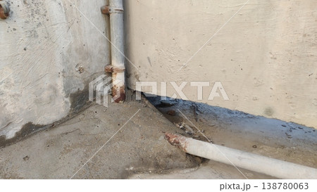 Rusted metal pipes with water damage on concrete wall Rusted metal pipes with water damage on concrete wall 138780063