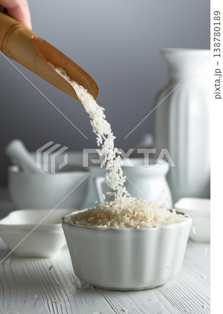 Raw organic rice is poured in white bowl. Raw organic rice is poured in white bowl. 138780189