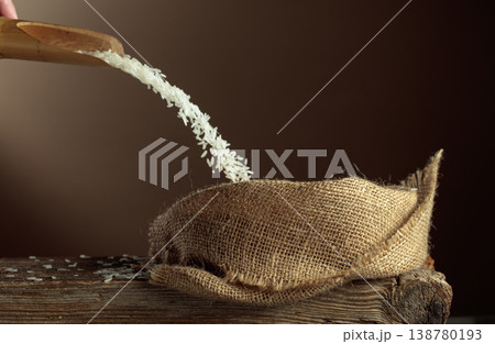 Rice is poured into a burlap bag. 138780193