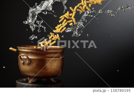 Vintage brass pot and pasta with a splash of water in motion. 138780195