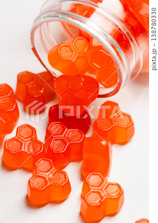 Jelly gummies close-up, fruit vitamins on bright background, food supplements.Orange vitamins in a jar Jelly gummies close-up, fruit vitamins on bright background, food supplements.Orange vitamins in a jar 138780330