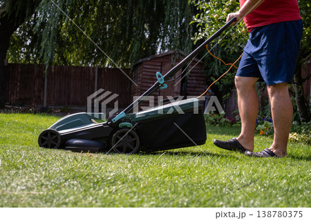 Lawn mowing in the garden, cutting green grass in the summer 138780375