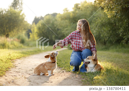 Female Rewards Dog During Training. Woman Gives Treat To Her Dog During Sunset Training Session 138780411