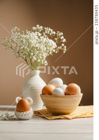 Easter eggs background. White eggs in wooden bowl and gypsophila flowers in a vase. Spring holiday 138780435