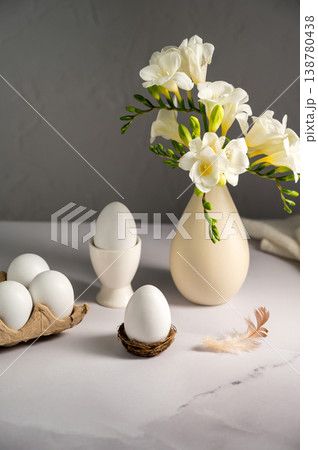 Spring, Easter background. White freesias flowers in a vase with white eggs. 138780438
