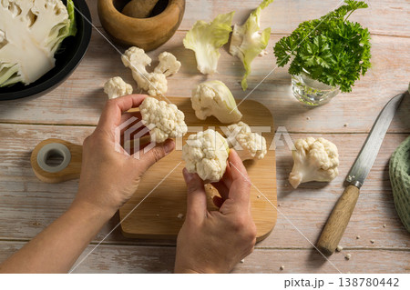 Female hands holding cauliflower lettuce pieces, cooking healthy vegetables Female hands holding cauliflower lettuce pieces, cooking healthy vegetables 138780442
