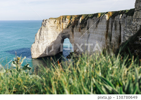 Etretat cliff arch with coastal grass and turquoise sea in Normandy France Etretat cliff arch with coastal grass and turquoise sea in Normandy France 138780649
