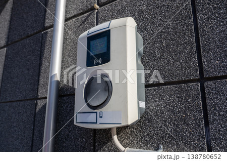Electric vehicle charging socket on wall with contactless payment terminal modern EV charging station concept 138780652