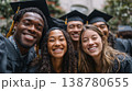 Happy diverse graduates taking selfie in graduation caps and gowns outdoors 138780655
