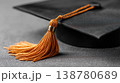 Black graduation cap with golden tassel closeup on dark background 138780689