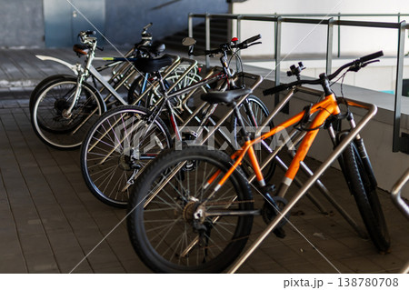 Row of parked bicycles with diverse frames in morning sunlight under protective shelter Row of parked bicycles with diverse frames in morning sunlight under protective shelter 138780708