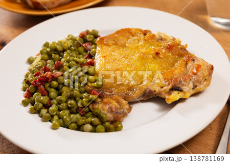 Fried boneless skinless chicken leg with green peas for garnish on plate Fried boneless skinless chicken leg with green peas for garnish on plate 138781169