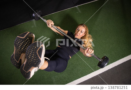 Fitness and health concept. A fit young woman works out in a modern gym. Athletic man doing exercise. 138781251