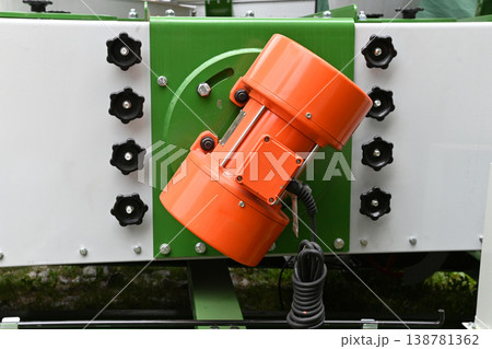 Orange motor part on workshop machinery 138781362