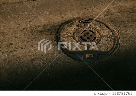 Metal manhole cover embedded in asphalt road surface in Belgrade. Concept of urban infrastructure, utilities and city maintenance Metal manhole cover embedded in asphalt road surface in Belgrade. Concept of urban infrastructure, utilities and city maintenance 138781763