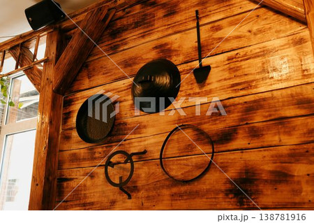 Wooden wall with traditional metal sac and cooking tools used for Balkan pita and burek preparation. Concept of regional cuisine, culinary heritage and authentic restaurant decor 138781916