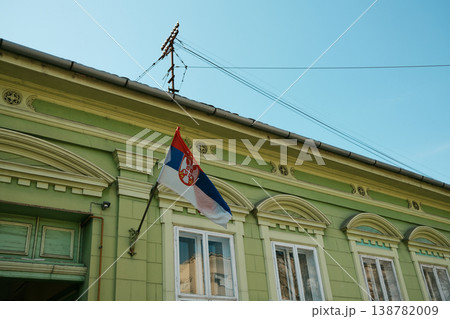 Serbian flag on historic building facade under clear sky with classic architectural details. Concept of national identity, culture and European heritage Serbian flag on historic building facade under clear sky with classic architectural details. Concept of national identity, culture and European heritage 138782009