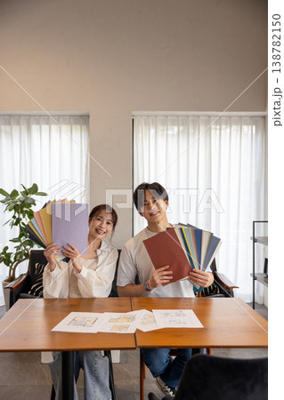 壁紙サンプルを持ってこっちを向いている若いカップル 壁紙サンプルを持ってこっちを向いている若いカップル 138782150