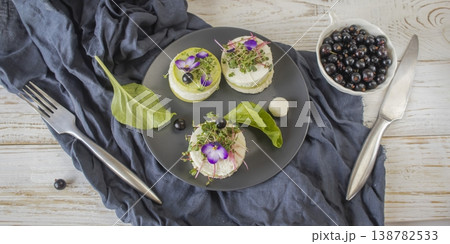 Exquisite mini cheesecakes with microgreens, soft cheese and edible flowers. Exquisite mini cheesecakes with microgreens, soft cheese and edible flowers. 138782533