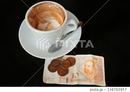 Cappuccino cup with Bosnia and Herzegovina convertible mark banknote and coins on dark table. Concept of cafe payment, tipping and coffee price in Balkan economy Cappuccino cup with Bosnia and Herzegovina convertible mark banknote and coins on dark table. Concept of cafe payment, tipping and coffee price in Balkan economy 138783957
