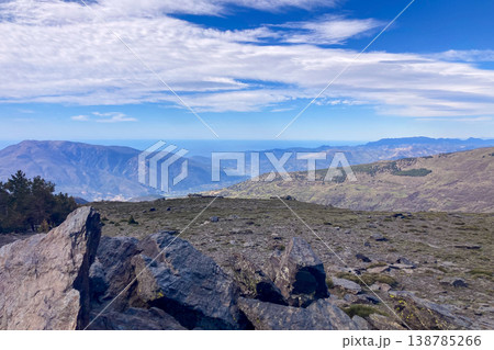 A hiking trail leads toward snow capped peaks revealing dramatic alpine terrain expansive vistas and crisp winter light in the Sierra Nevada Mountains in Spain A hiking trail leads toward snow capped peaks revealing dramatic alpine terrain expansive vistas and crisp winter light in the Sierra Nevada Mountains in Spain 138785266