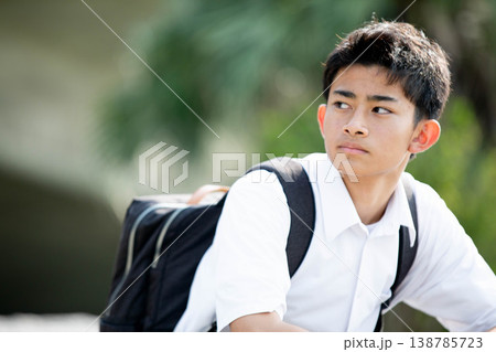 リュックを背負って遠くを見つめる爽やかな男子学生 リュックを背負って遠くを見つめる爽やかな男子学生 138785723