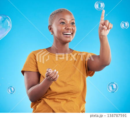 Black woman, pop bubbles and happiness, fun and vibrant with entertainment isolated on blue background. Liquid soap, freedom and African female person, playful with activity and enjoy in studio 138787591