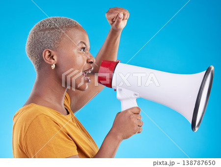 Black woman, megaphone and protest in studio, shout or profile with fist in air for human rights by blue background. African gen z student, girl and audio tech for power, opinion or news announcement Black woman, megaphone and protest in studio, shout or profile with fist in air for human rights by blue background. African gen z student, girl and audio tech for power, opinion or news announcement 138787650