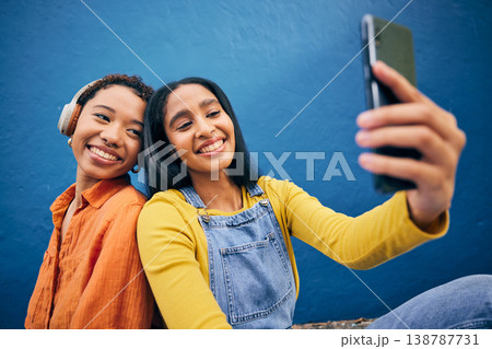 Phone, selfie and women in city on blue background online for social media, internet and profile picture. Friendship, happy and female people relax on smartphone listening to song, track and radio Phone, selfie and women in city on blue background online for social media, internet and profile picture. Friendship, happy and female people relax on smartphone listening to song, track and radio 138787731