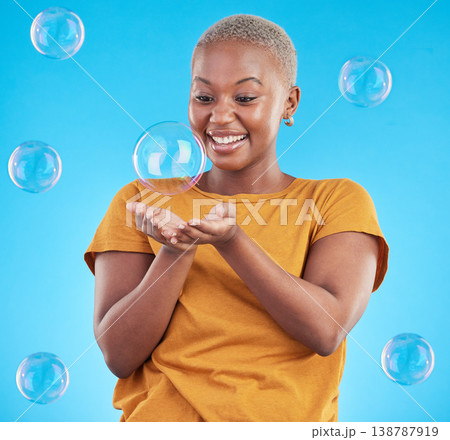 Black woman, play with bubbles and happiness, fun and vibrant with entertainment on blue background. Liquid soap, freedom and African female person, playful with activity and enjoy in a studio 138787919