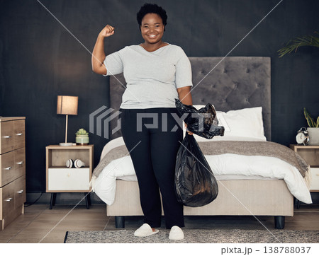 Black woman, garbage bag and champion, success in cleaning and bedroom with hygiene in portrait. Strong female cleaner, winner at housekeeping with smile, morning routine and maintenance at home Black woman, garbage bag and champion, success in cleaning and bedroom with hygiene in portrait. Strong female cleaner, winner at housekeeping with smile, morning routine and maintenance at home 138788037
