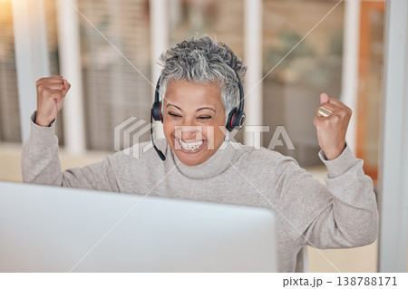 Computer, success and a senior woman in a call center for customer service, support or motivation. Contact, headset and a happy female consultant in celebration at a desk in a professional crm office 138788171