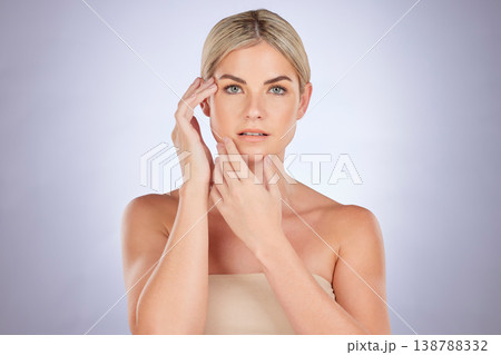 Beauty, portrait and woman touch face for aesthetic check, soft skincare glow or plastic surgery for anti aging treatment. Cosmetics, results and female model with studio makeup on purple background Beauty, portrait and woman touch face for aesthetic check, soft skincare glow or plastic surgery for anti aging treatment. Cosmetics, results and female model with studio makeup on purple background 138788332