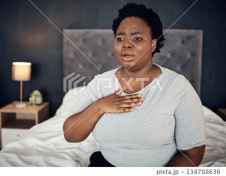 Fear, sick and a black woman with an anxiety attack or pain in chest from stress. Scary, health and an African girl on a bed with panic, depression or a mental health illness or fail in the bedroom 138788636