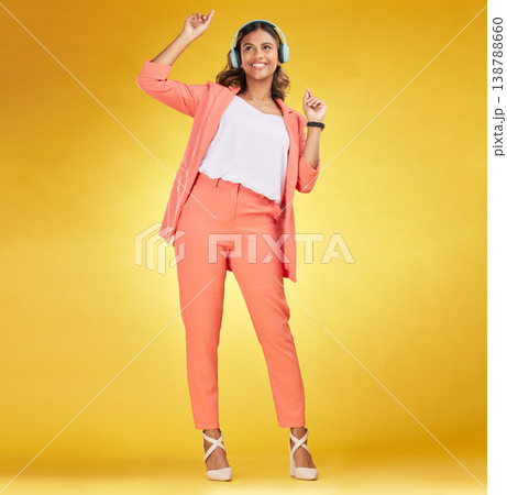 Woman, headphones and happy dance to music in studio for fashion, freedom and audio energy on yellow background. Indian model, style and dancing to celebration, listening to radio and streaming sound Woman, headphones and happy dance to music in studio for fashion, freedom and audio energy on yellow background. Indian model, style and dancing to celebration, listening to radio and streaming sound 138788660